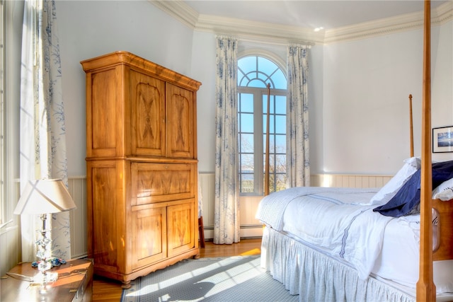 bedroom with multiple windows, ornamental molding, and light wood-type flooring