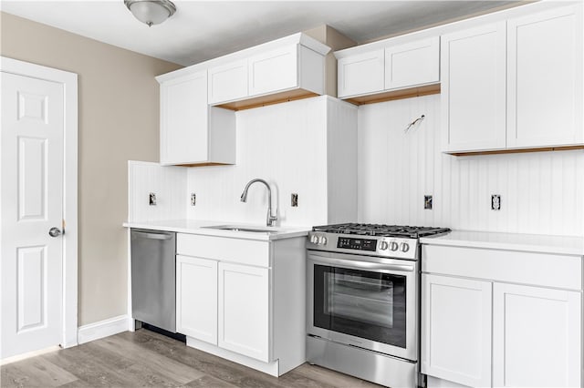 kitchen with sink, white cabinetry, hardwood / wood-style flooring, and stainless steel appliances