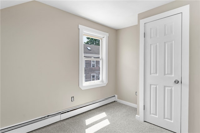 unfurnished bedroom featuring a baseboard heating unit and light colored carpet