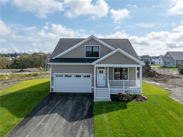 view of front of house featuring a garage, a front yard, and covered porch