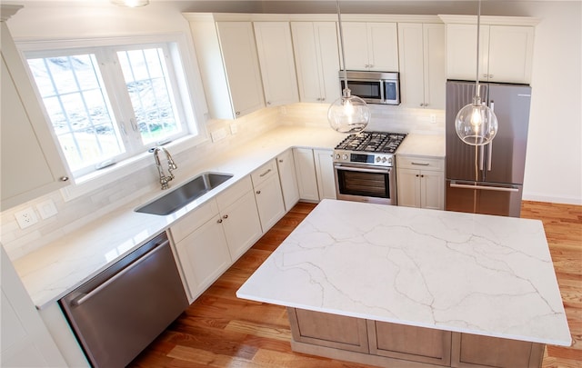 kitchen with stainless steel appliances, light hardwood / wood-style flooring, a center island, and white cabinetry