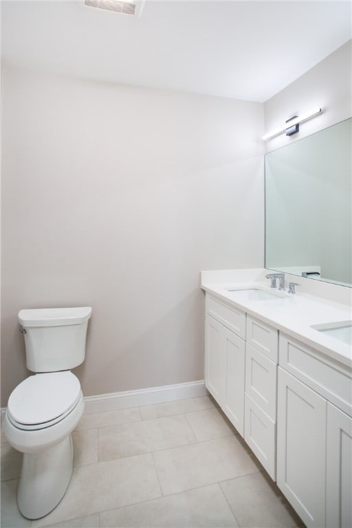 bathroom featuring tile patterned flooring, vanity, and toilet