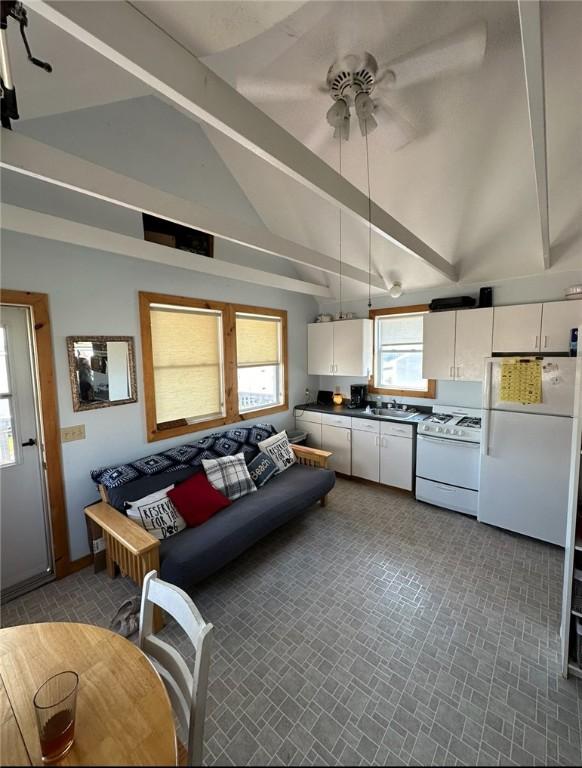 living room featuring beamed ceiling, ceiling fan, sink, and high vaulted ceiling