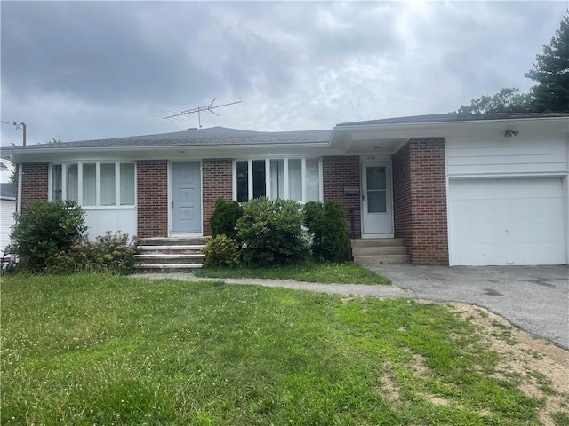 single story home featuring a garage and a front lawn