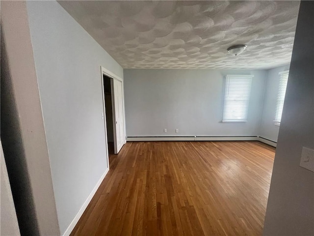 spare room with hardwood / wood-style floors and a textured ceiling