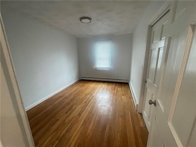 empty room with a baseboard radiator and light wood-type flooring