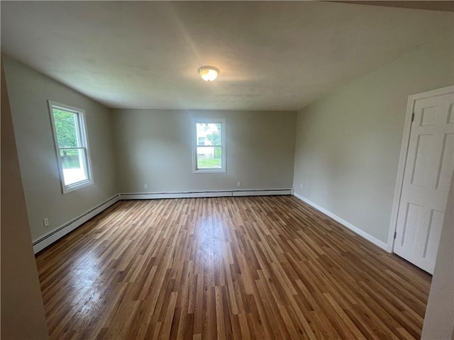 empty room with dark wood-type flooring and a baseboard heating unit