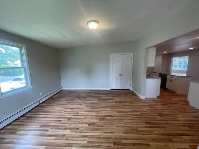 spare room featuring light wood-type flooring and baseboard heating