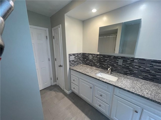 bathroom featuring vanity and backsplash