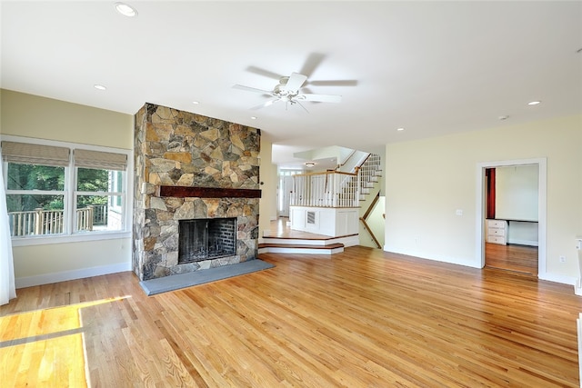 unfurnished living room featuring ceiling fan, a fireplace, and light hardwood / wood-style flooring