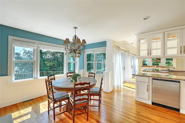 dining room featuring a notable chandelier, light hardwood / wood-style flooring, and sink