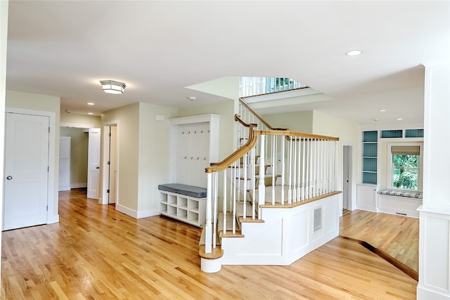 stairway with light hardwood / wood-style floors