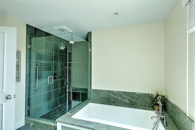 bathroom featuring tile patterned flooring, separate shower and tub, and radiator heating unit