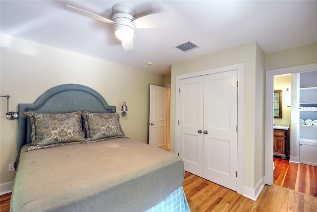 bedroom featuring light hardwood / wood-style flooring, a closet, connected bathroom, and ceiling fan