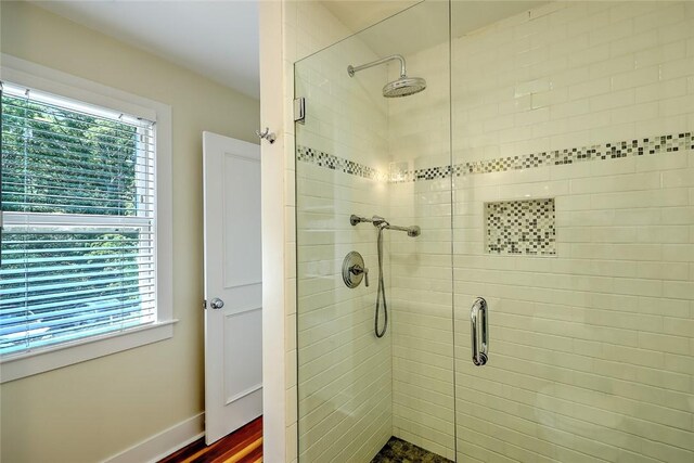 bathroom featuring a shower with shower door and wood-type flooring