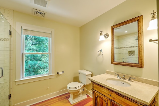 bathroom with a healthy amount of sunlight, vanity, wood-type flooring, and toilet