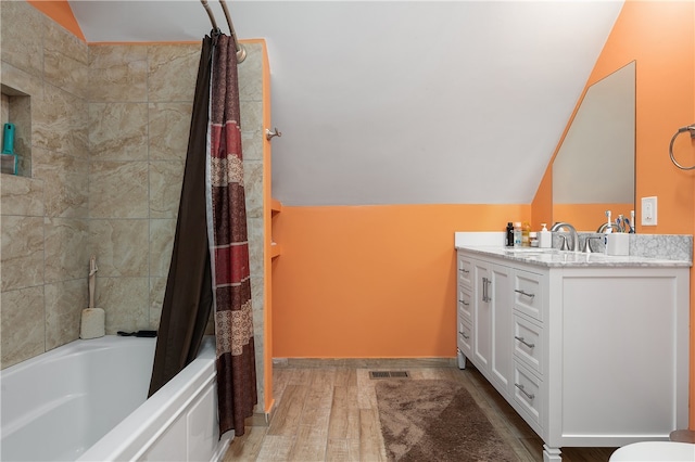 bathroom featuring vanity, shower / bath combo with shower curtain, lofted ceiling, and hardwood / wood-style floors