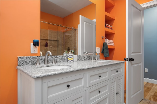 bathroom with vanity, hardwood / wood-style flooring, and walk in shower