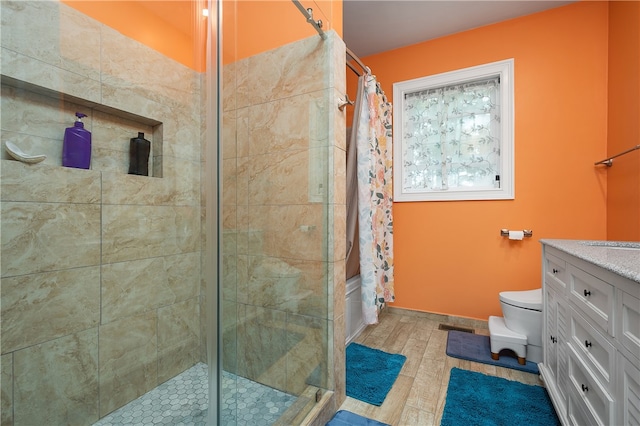 bathroom featuring vanity, curtained shower, hardwood / wood-style flooring, and toilet