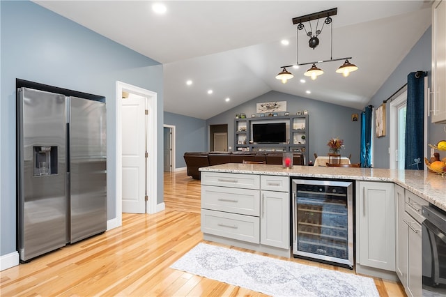 kitchen featuring stainless steel fridge, vaulted ceiling, decorative light fixtures, beverage cooler, and light hardwood / wood-style flooring