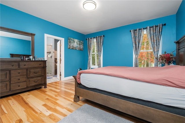 bedroom featuring ensuite bath and hardwood / wood-style flooring