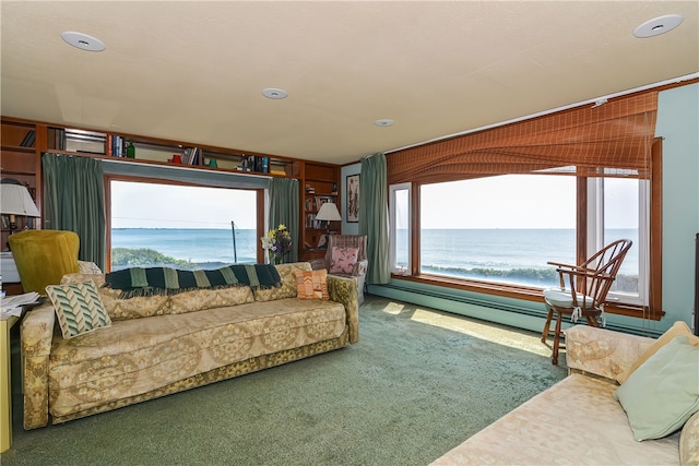 carpeted living room with a water view and a baseboard heating unit