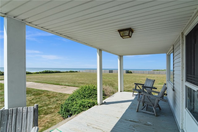 wooden deck with a lawn and a water view