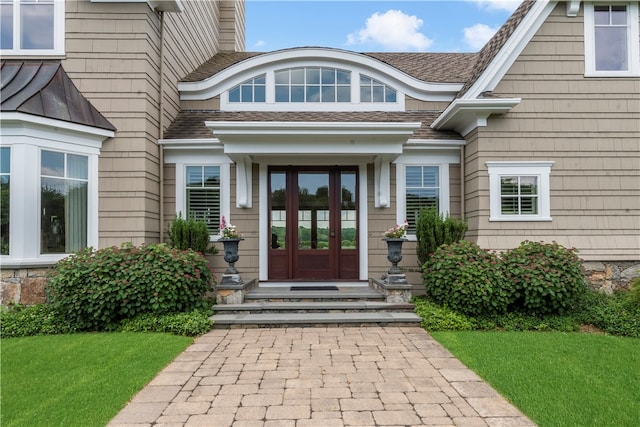 view of exterior entry featuring a yard