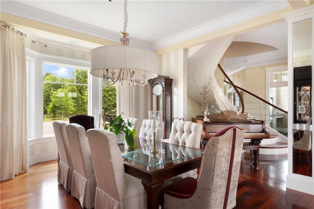 dining room featuring stairs, wood finished floors, ornamental molding, and an inviting chandelier