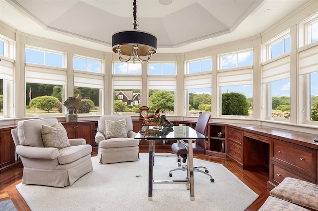 sunroom / solarium with a notable chandelier, a healthy amount of sunlight, and a raised ceiling