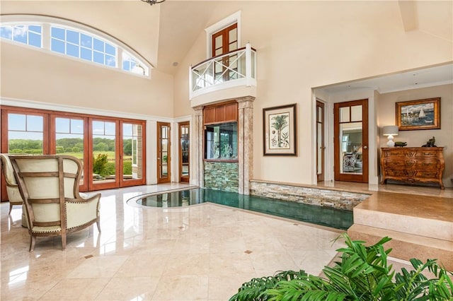 foyer featuring marble finish floor and a high ceiling