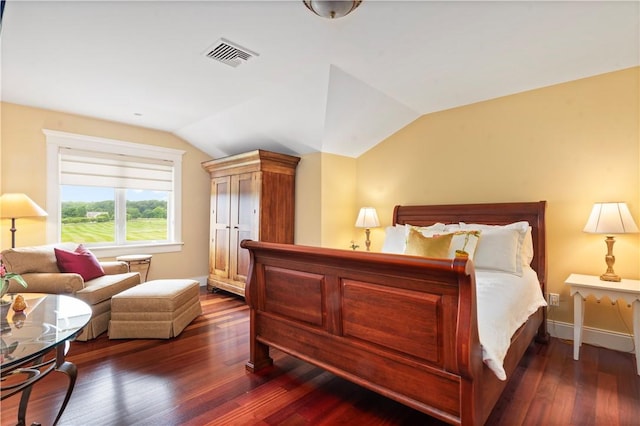 bedroom with wood finished floors, baseboards, lofted ceiling, and visible vents