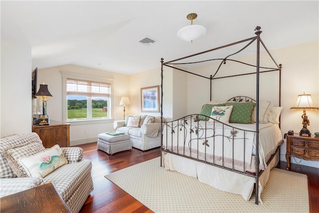 bedroom with wood finished floors, baseboards, lofted ceiling, and visible vents
