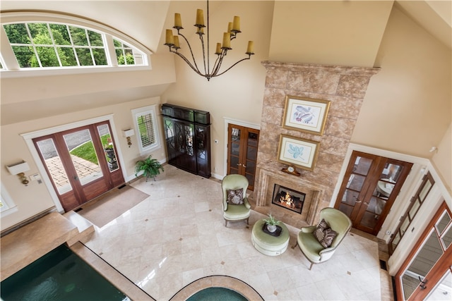 entryway with french doors, a healthy amount of sunlight, tile patterned flooring, and a towering ceiling