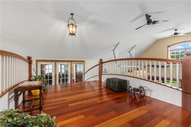 sitting room with hardwood / wood-style floors, vaulted ceiling, an upstairs landing, and a ceiling fan