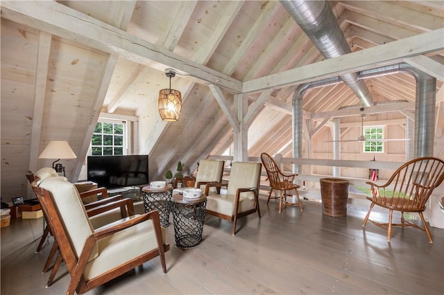 sitting room with lofted ceiling with beams and wood finished floors