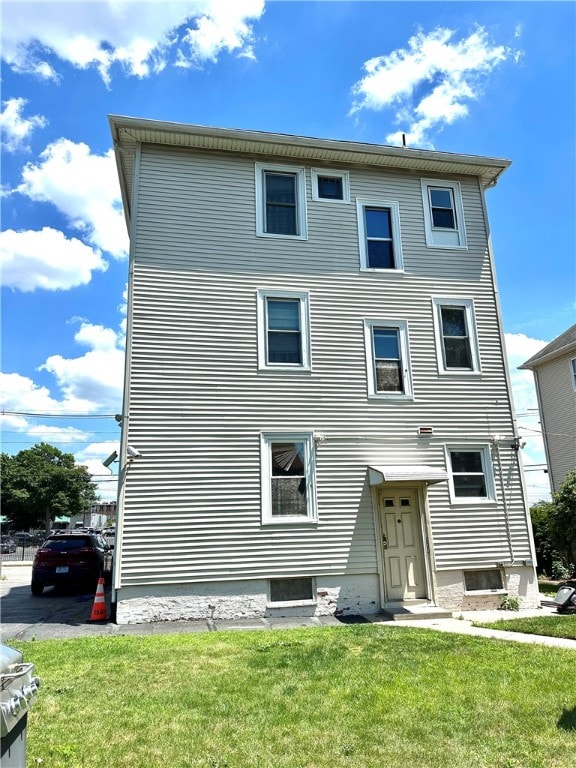 rear view of house featuring a yard