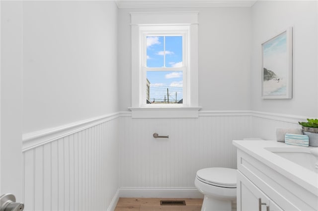 bathroom featuring ornamental molding, vanity, toilet, and hardwood / wood-style floors