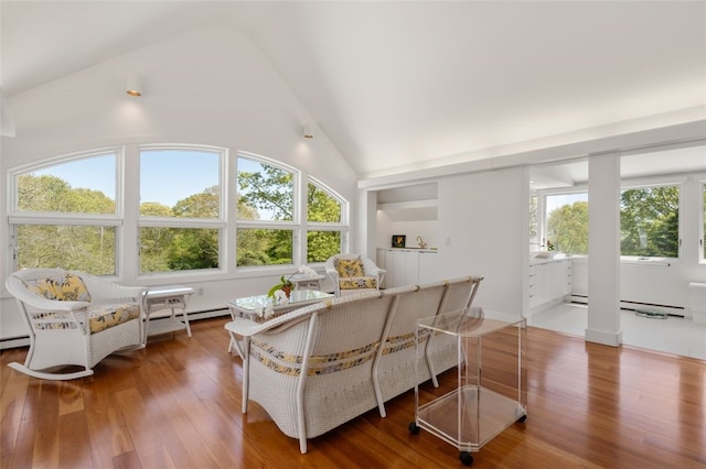 living room with baseboard heating, a wealth of natural light, and hardwood / wood-style flooring