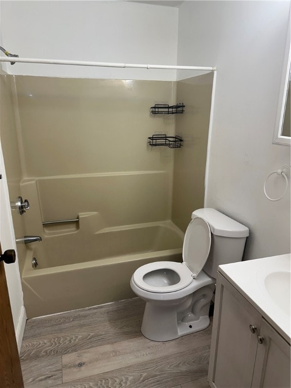 full bathroom with vanity, toilet,  shower combination, and hardwood / wood-style floors