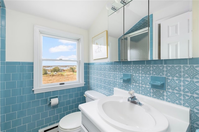 bathroom featuring tile walls, toilet, vanity, and a shower with shower door