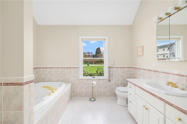 bathroom with vanity, tiled bath, tile patterned flooring, tile walls, and toilet