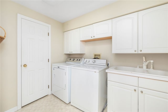 laundry room with cabinets, sink, and washing machine and dryer