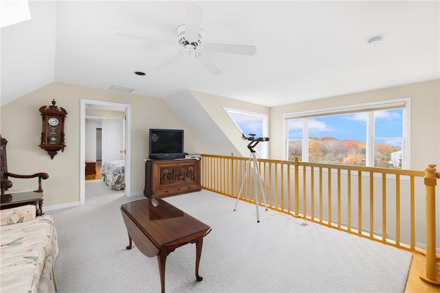 living room with carpet flooring, vaulted ceiling with skylight, and ceiling fan