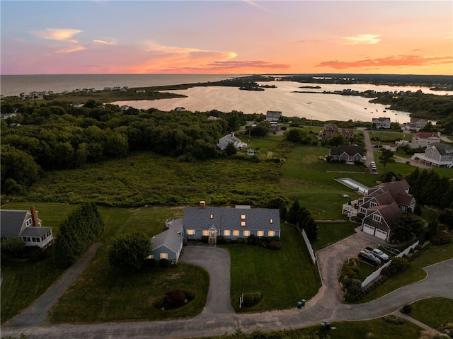 aerial view at dusk featuring a water view