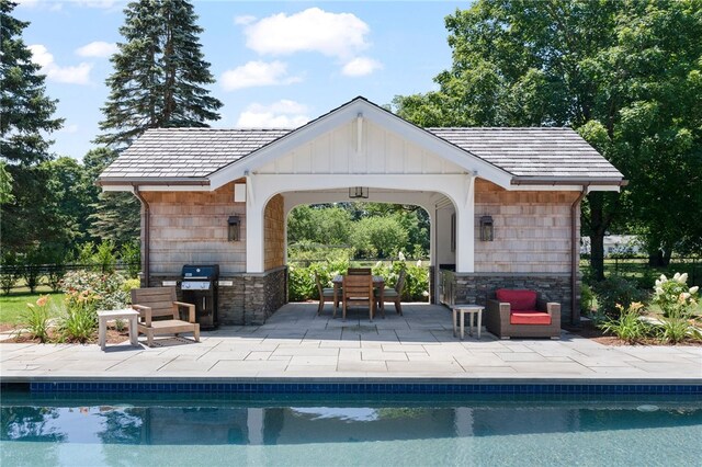 view of pool featuring a patio area and an outbuilding