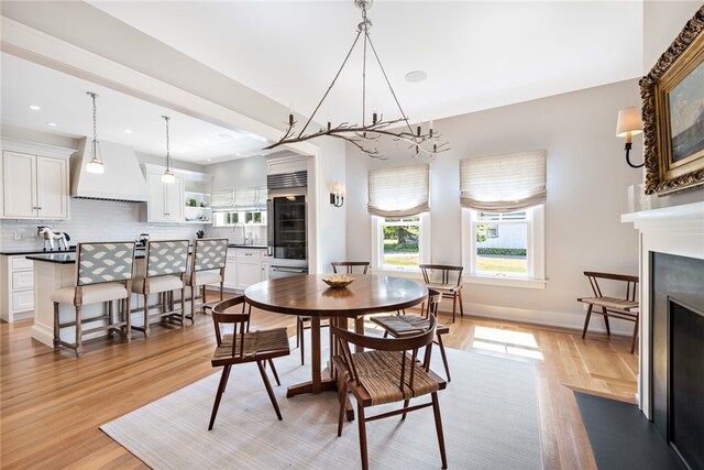 dining area with light hardwood / wood-style floors and a chandelier