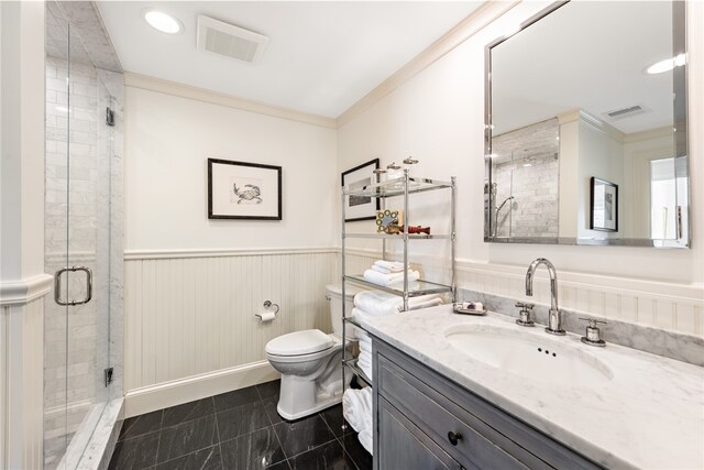 bathroom with ornamental molding, vanity, a shower with shower door, and toilet