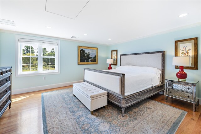 bedroom featuring ornamental molding and hardwood / wood-style floors