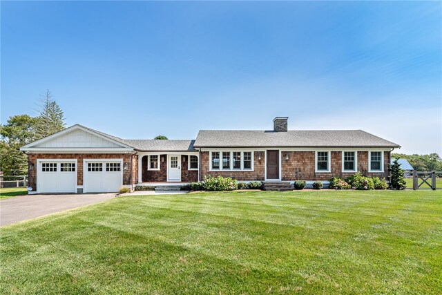 ranch-style house featuring a garage and a front lawn